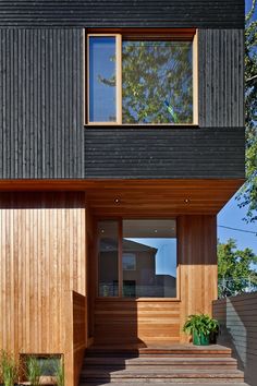 a house with wood siding and windows on the outside, along with wooden steps leading up to it