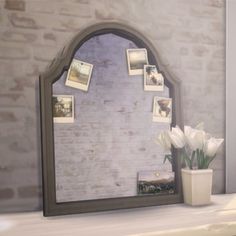 a mirror sitting on top of a mantle next to a vase filled with flowers