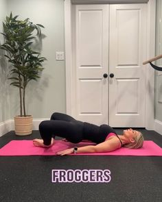 a woman is doing a yoga pose on a pink mat in front of a door