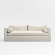 a white couch sitting on top of a white floor