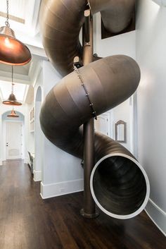 a large metal object hanging from the side of a wall next to a wooden floor