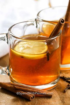 two mugs filled with tea and cinnamon sticks