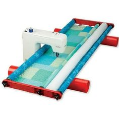 an inflatable water slide with a sewing machine on the top and blue fabric under it