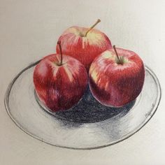 two apples are sitting on a plate with colored pencils