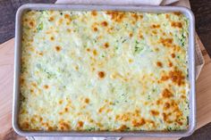 a casserole dish with cheese and broccoli in it