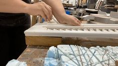 a person is cutting out some kind of cake on a wooden table in a shop