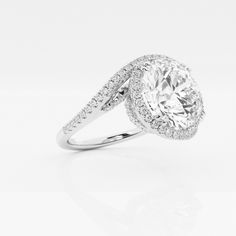 a white gold ring with diamonds on the sides and an oval center stone in the middle