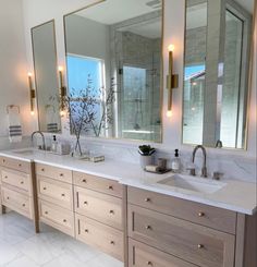 a large bathroom with two sinks and mirrors on the wall next to eachother