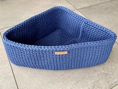 a blue knitted basket sitting on the ground