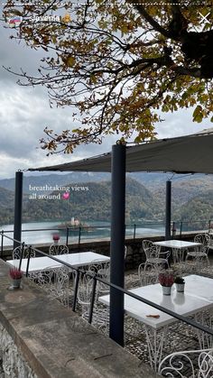 tables and chairs are set up on the side of a hill overlooking a body of water