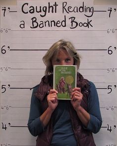 a woman holding up a book in front of her face