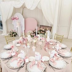 the table is set with pink and white plates