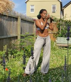 a woman is standing in the yard with her hands on her face and looking up