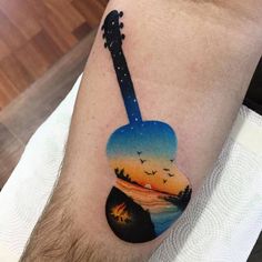 a man with a guitar tattoo on his arm