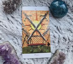 a tarot card sitting on top of a furry surface next to rocks and stones