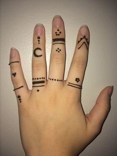 two fingers with different tattoos on them and one has a moon, stars, and hearts