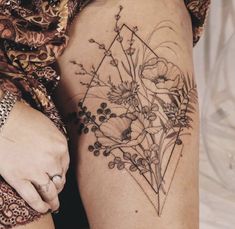 a woman's thigh with flowers and triangles on it