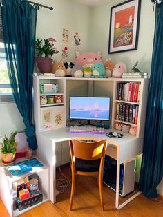 a desk with a computer on top of it in front of a window filled with curtains