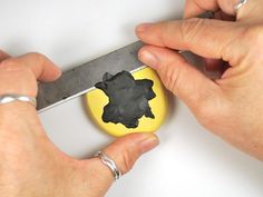 someone is using a pair of scissors to cut out a piece of black and yellow paper