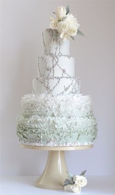 a white wedding cake with flowers on top is featured in the new york times magazine