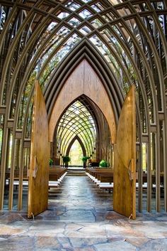 the inside of a church with wooden doors and pews lined up on either side