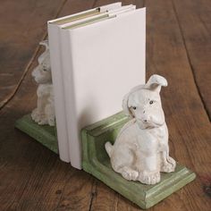 a small white dog figurine sitting next to a book