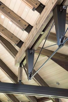 the inside of a building that has wooden beams and metal brackets hanging from it's ceiling