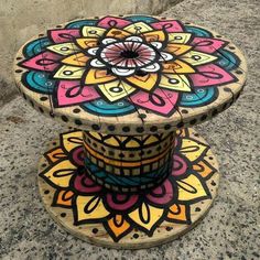 an artisticly painted wooden stand on the ground with words above it that read, i am not sure what this item is