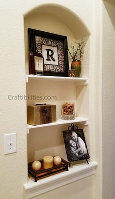 a shelf with candles and pictures on it