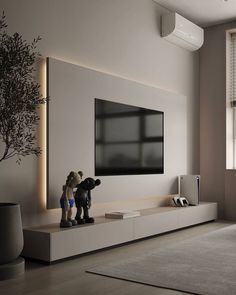 two figurines are standing in front of a television on a wall mounted entertainment unit