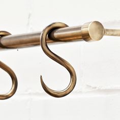 a close up of a metal hook on a white brick wall