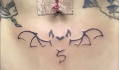 the back of a woman's stomach with bats drawn on it and an arrow in the middle