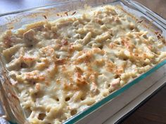 a casserole dish filled with macaroni and cheese on a wooden table