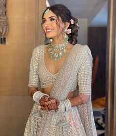 a woman wearing a white outfit and jewelry