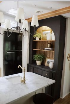 a kitchen with black cabinets and white counter tops