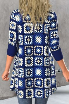 a woman wearing a blue and white crochet sweater