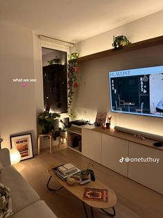 a living room filled with furniture and a flat screen tv mounted on the wall above a wooden coffee table