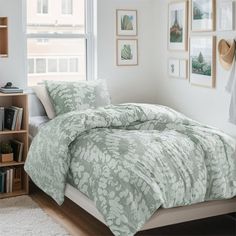 a bed in a bedroom with a green comforter and matching pillow cases on top of it