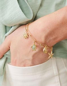 Make a splash with our Seashore Charm bracelet. Inspired by our favorite marine life, this piece shows our love for the sea. Designed to shine through everyday wear, exercise, showers and a summer at the beach in tarnish free 14kt gold vacuum plating. Women's Seashore Charm Bracelet 7.5" size 5" by Spartina 449 Charm Jewelry For Beach, Beach Charms Bracelet Jewelry, Adjustable Gold Charm Bracelet Ocean-inspired, Adjustable Starfish Charm Bracelet, Vacation Bracelet With Starfish Charm, Adjustable Gold Charm Bracelet With Starfish Charm, Vacation Bracelet With Lobster Clasp, Starfish Charm Dangle Jewelry, Adjustable Chain Bracelet For Beach