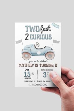 a person holding up a two fast 2 car birthday card