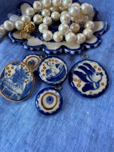 several blue and white porcelain items on a table with pearl necklaces, brooch pins, and pearls