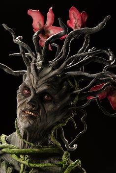 a close up of a person with flowers on their head and branches in his hair