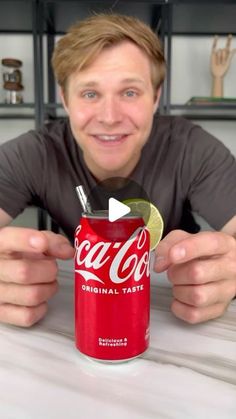 a man sitting at a table with a can of coca - cola in front of him