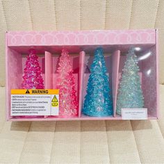 three different colored christmas trees in a pink box