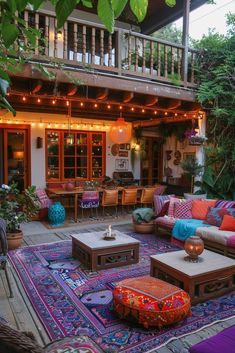 an outdoor living room with lots of furniture and lights hanging from the roof above it