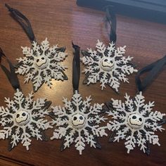 four snowflakes are sitting on a table with black ribbon around the edges