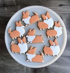 a plate full of cut out cookies with corgi on them