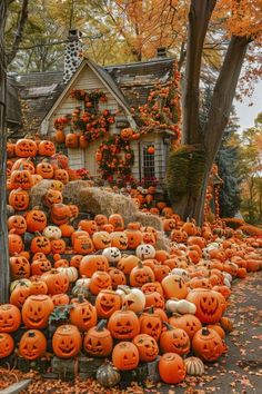 pumpkins are piled up in front of a house