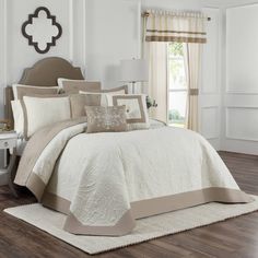 a bed with white and beige comforters in a room