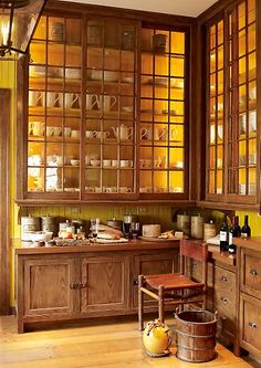 an old fashioned kitchen with wooden cabinets and glass doors on the wall, along with wood flooring